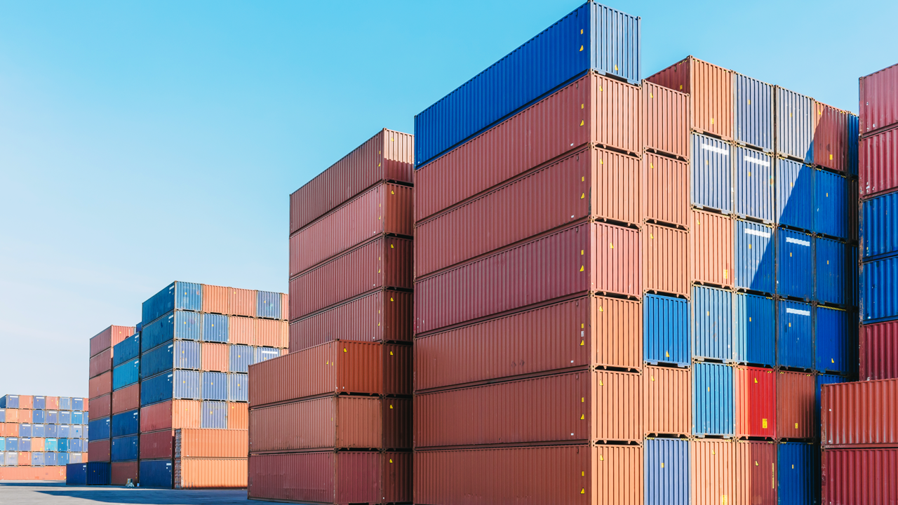 Stacked shipping containers at an industrial port — representative of the imported truck and bus tires now under a Canadian trade investigation