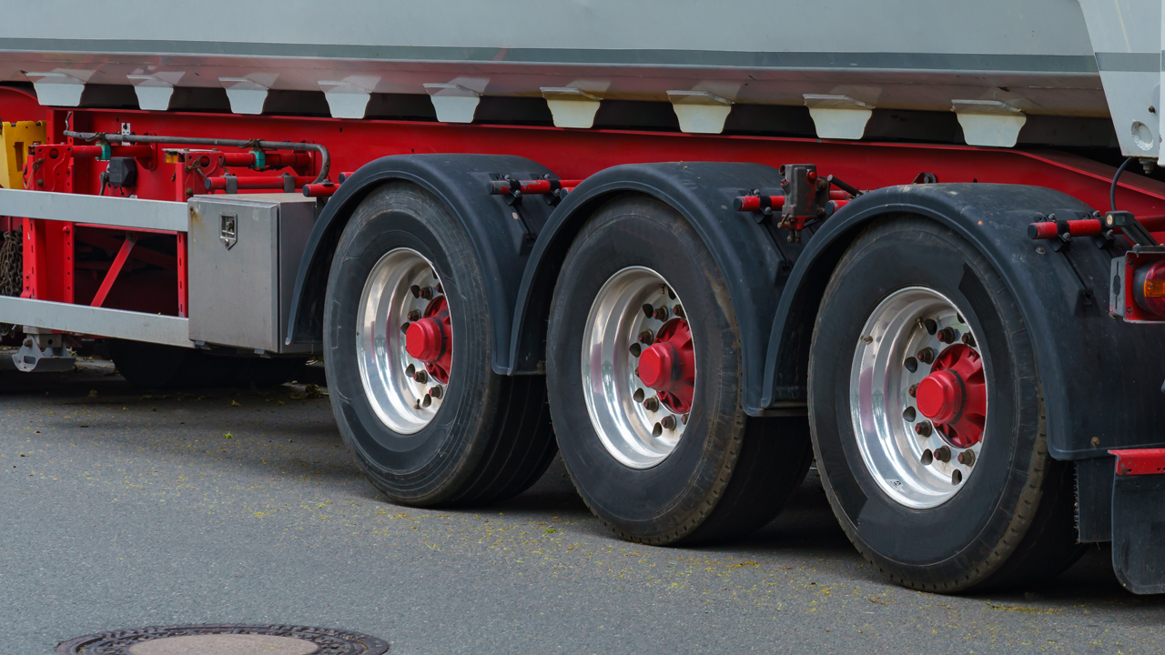 Close-up of heavy truck trailer wheels and rims — the bead-and-rim interface curing rims, flanges, and expandable hubs are built to seal during the cure cycle