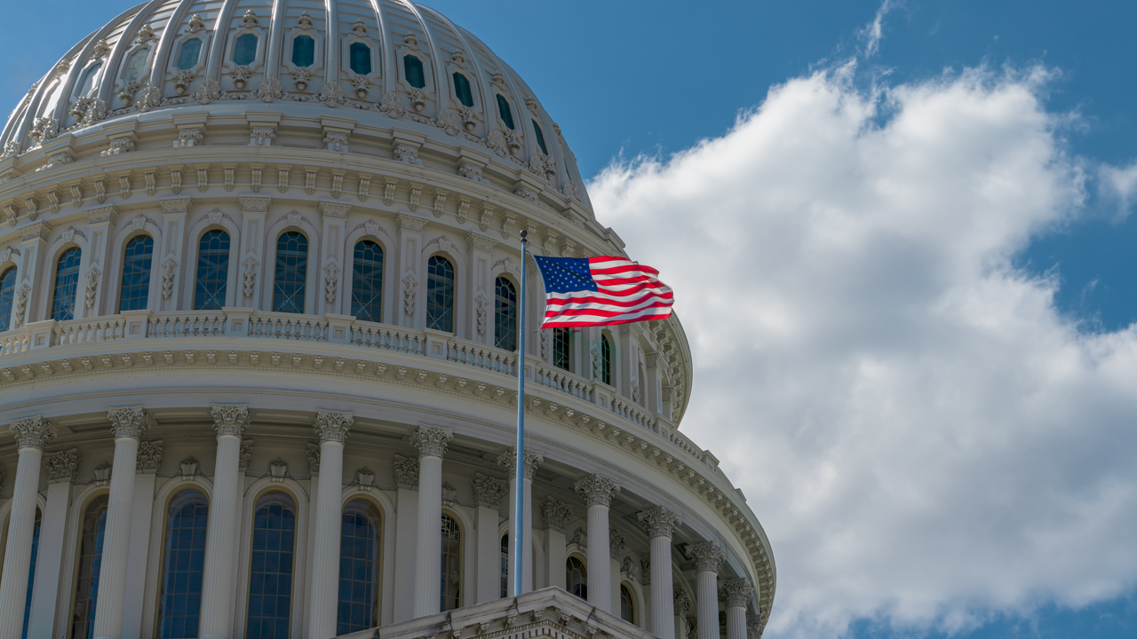 U.S. Capitol building dome with an American flag flying — where the Retreaded Tire Jobs, Supply Chain Security, and Sustainability Act is currently pending