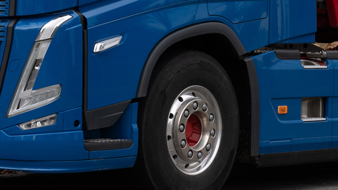 Commercial truck tractor at a highway inspection stop, steering axle and tires visible — the position Canada's National Safety Code treats differently from the US