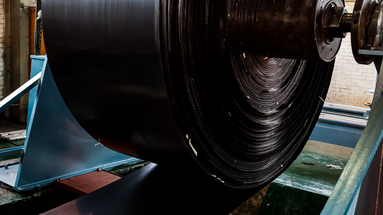 Large roll of rubber material on an industrial spool — tread rubber and cushion gum are living compounds that degrade in storage well before they ever reach a casing